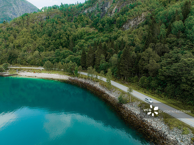 航拍的汽车在公路附近的湖在挪威日落图片素材