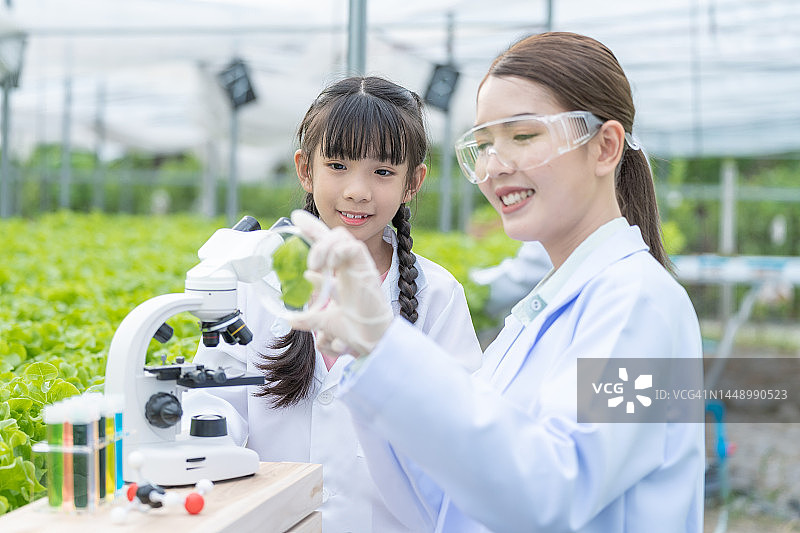 年轻的男科学家教女孩在有机农场种植植物图片素材