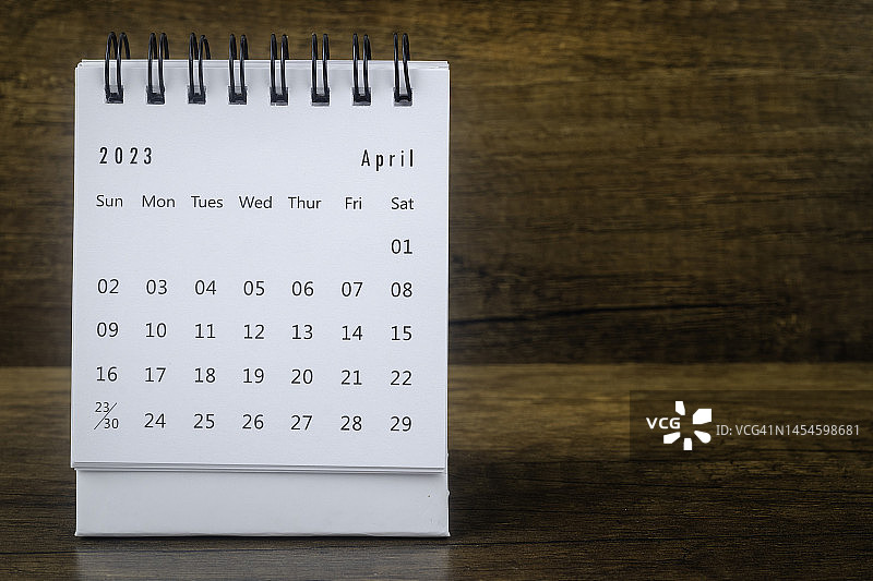 日历桌2023:4月是组织者计划和截止日期的月份，背景是木桌。图片素材