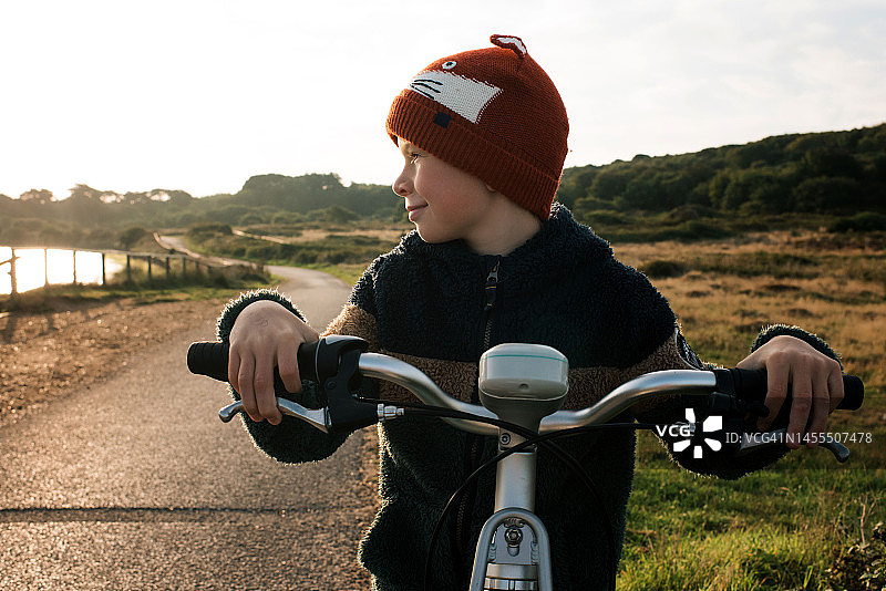男孩在海边租自行车看日出图片素材
