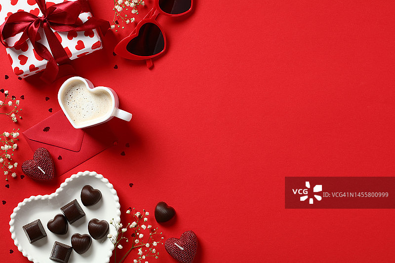 情人节快乐作文。平铺礼盒，心形咖啡杯，糖果，蜡烛，红色背景的鲜花。爱，浪漫的概念。图片素材