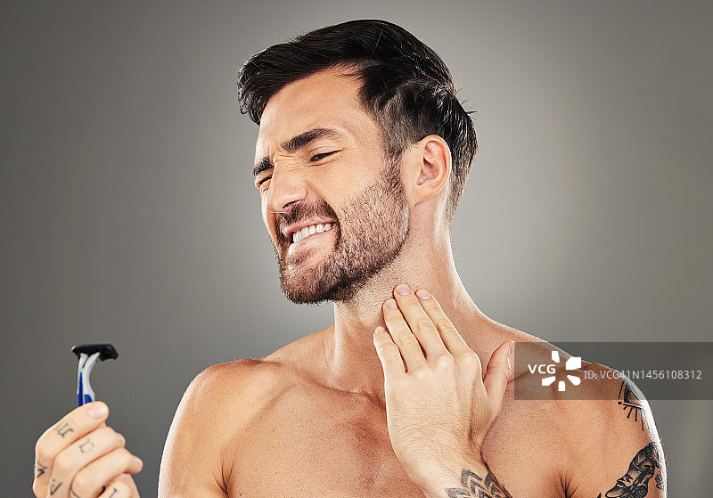 男人，面部和剃须疼痛的颈部护肤美容或化妆品健康在工作室。面部护理，卫生皮肤科美容事故和剃须为皮肤保健在灰色背景图片素材