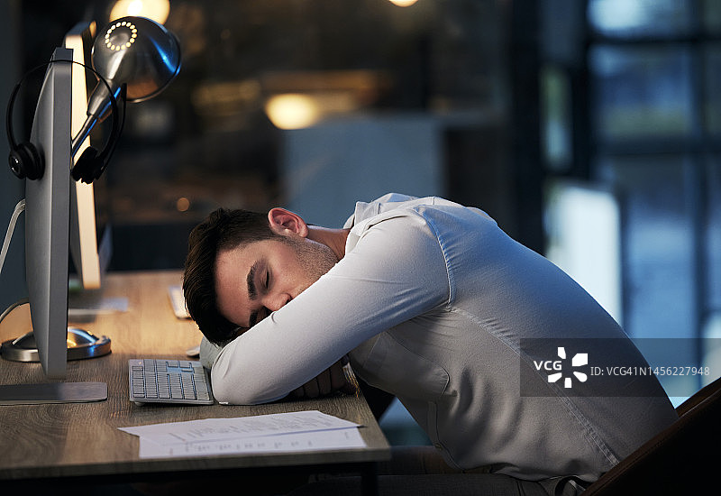 男人，在呼叫中心办公室睡得精疲力竭，在客户关系管理合规咨询公司工作过度劳累。商人，睡眠和心理健康压力从公司文件规划在线图片素材