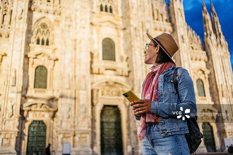 一名年轻女子在米兰大教堂前打电话图片素材