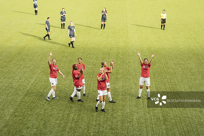 在体育场举行的足球比赛中，开心的女队员们正在鼓掌图片素材