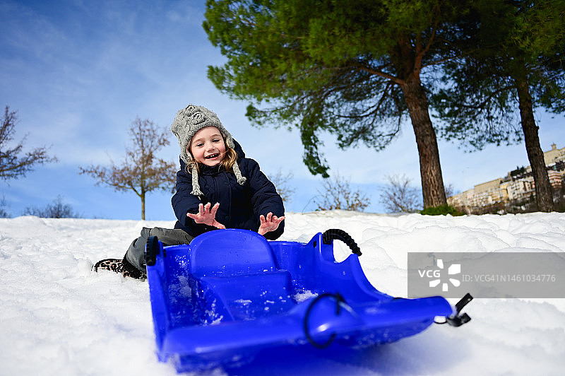 小女孩在玩雪橇。图片素材