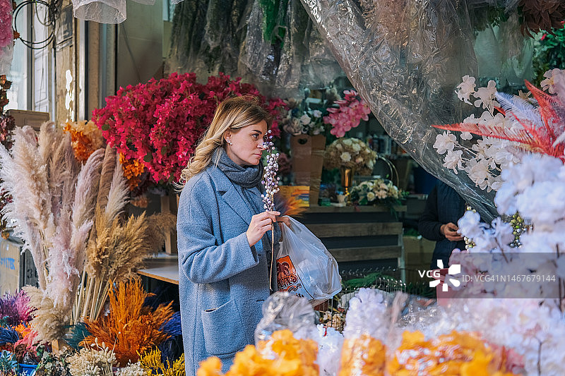 装饰花店的女人在市场上偷东西。图片素材