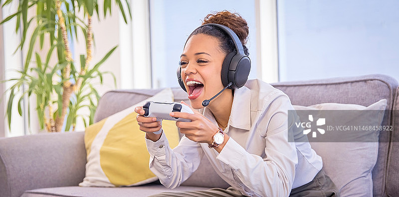 电子游戏，耳机和女玩家在沙发上玩电子竞技，在线游戏和虚拟比赛。年轻女性，带耳机的游戏流媒体和控制器，在沙发上，客厅和家里玩图片素材