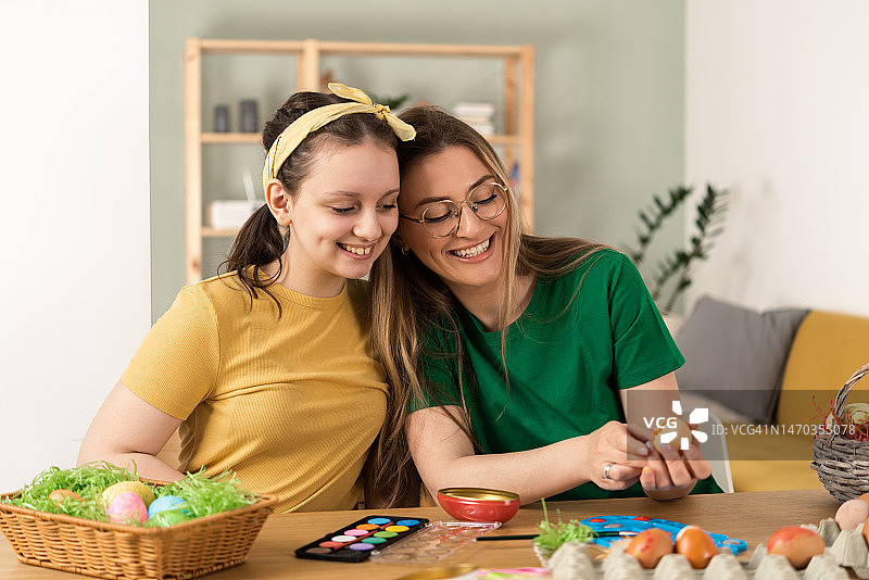 女孩和她的妈妈准备了一个装满彩色复活节彩蛋的篮子图片素材