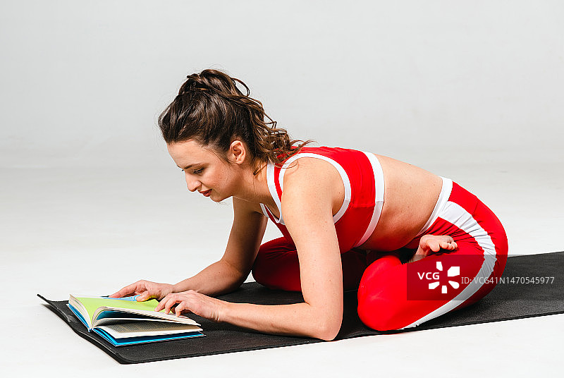 一位美女穿着红色运动服在瑜伽课上进行减肥运动图片素材