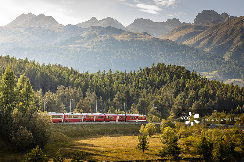 红色火车与阿尔卑斯山景观附近的圣莫里茨，恩加丁山谷，格劳宾登，瑞士阿尔卑斯山图片素材