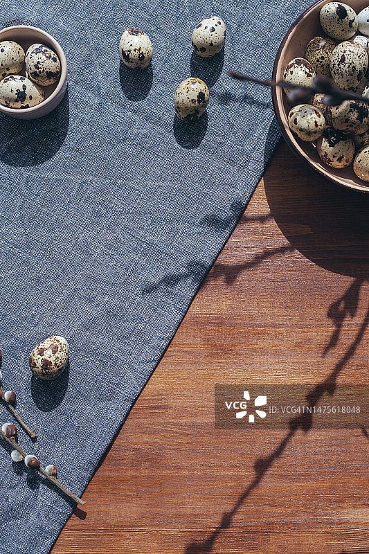 复活节明信片与一盘鸡蛋织物桌布和木制背景。图片素材