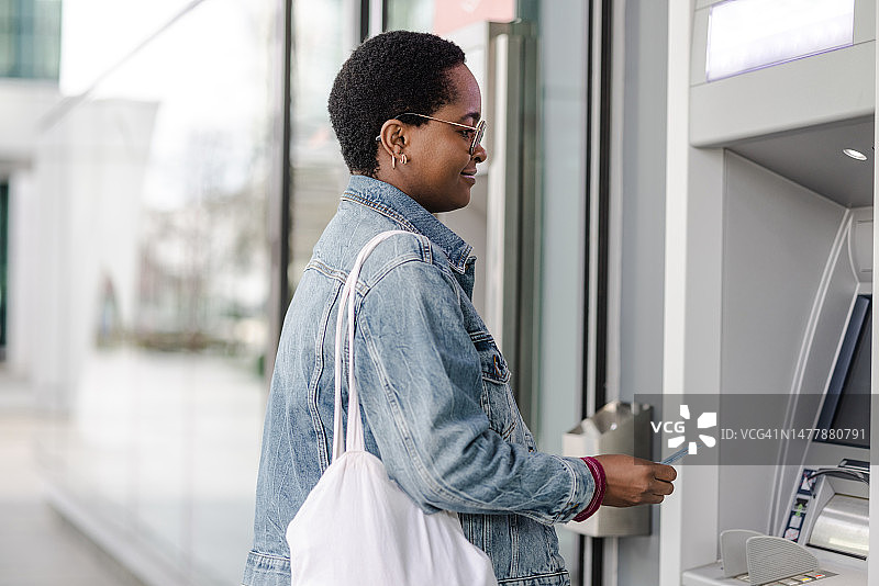 一名非洲裔美国妇女正在使用自动取款机图片素材