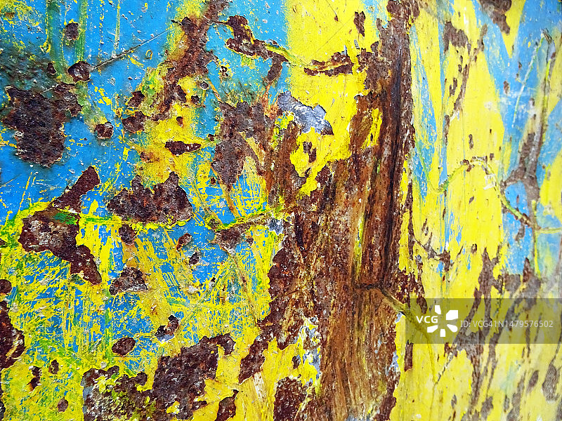 侧面视图风化和划痕的蓝色和黄色油漆在生锈的金属板在巴黎，法国图片素材