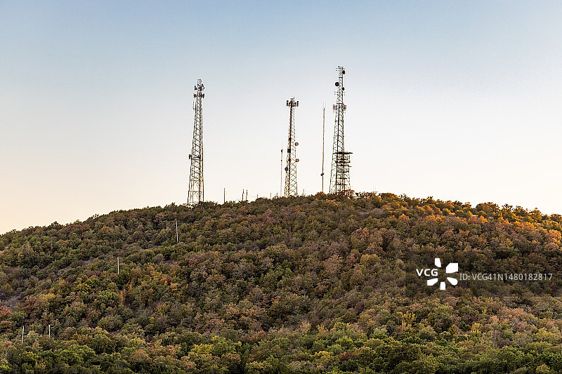 通信塔天线在山顶与森林。图片素材