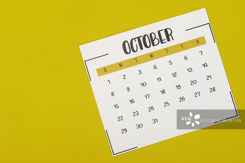 日历台2023:10月是组织者以黄色纸张为背景进行计划和截止日期的月份。图片素材