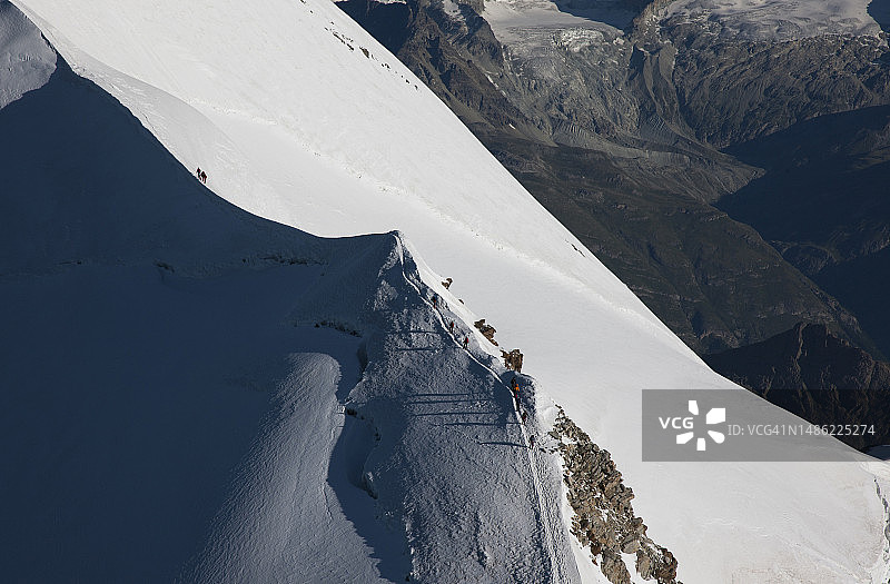 登山者在白雪皑皑的山脊上图片素材