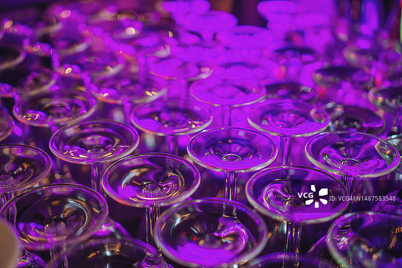 摆放整齐的酒杯反射出紫光图片素材