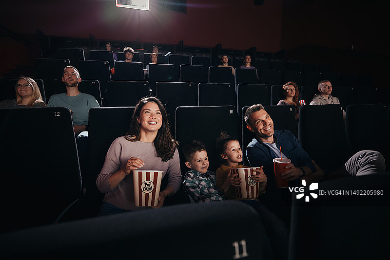 一家人在影院看电影。图片素材