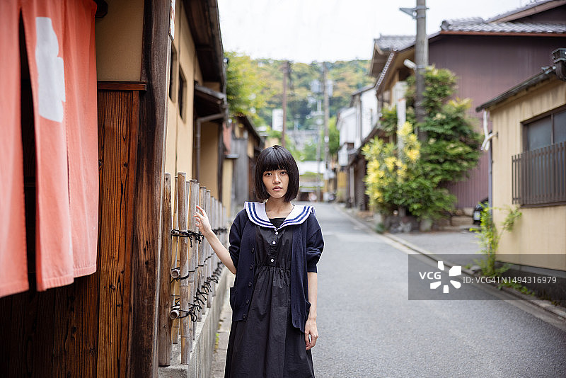 一名妇女走在传统的日本村庄里图片素材