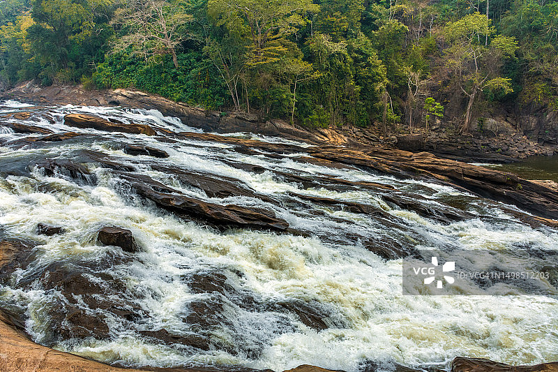 印度，河流穿过森林里的岩石图片素材