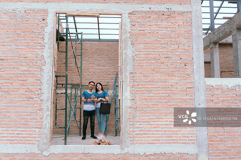 一对亚洲夫妇正在检查房子，计划建造合适的房子图片素材