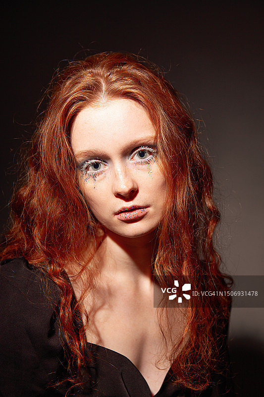 一个年轻漂亮的红发女人的艺术肖像，她的妆容很有艺术感图片素材