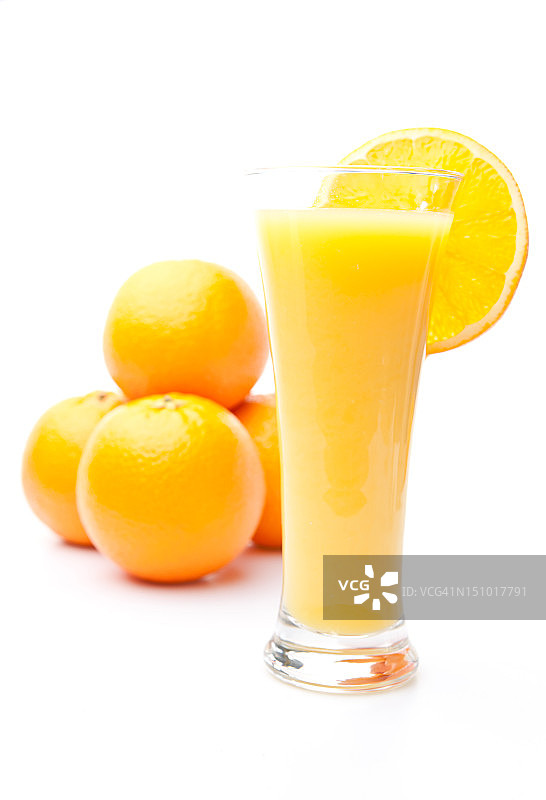 一堆橘子在一杯橙汁后面图片素材