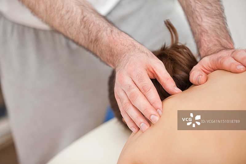 脊椎按摩师抚摸病人的背部图片素材