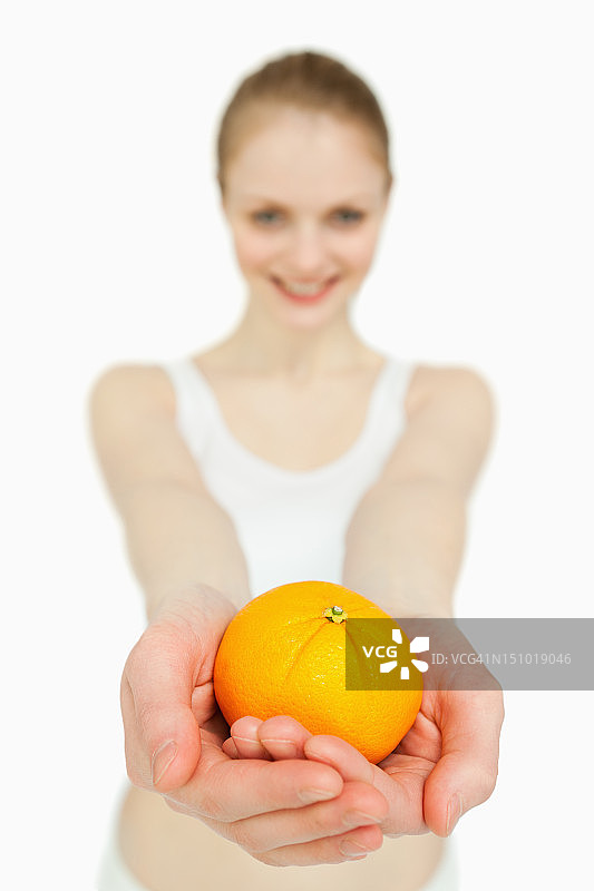一个女人展示橘子的特写图片素材