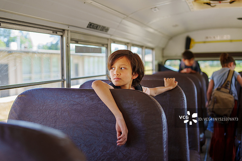 沉思的学生独自坐在校车上图片素材