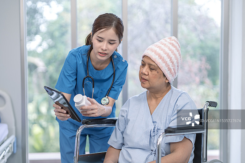 亚洲护士在医院给癌症病人的用药建议图片素材