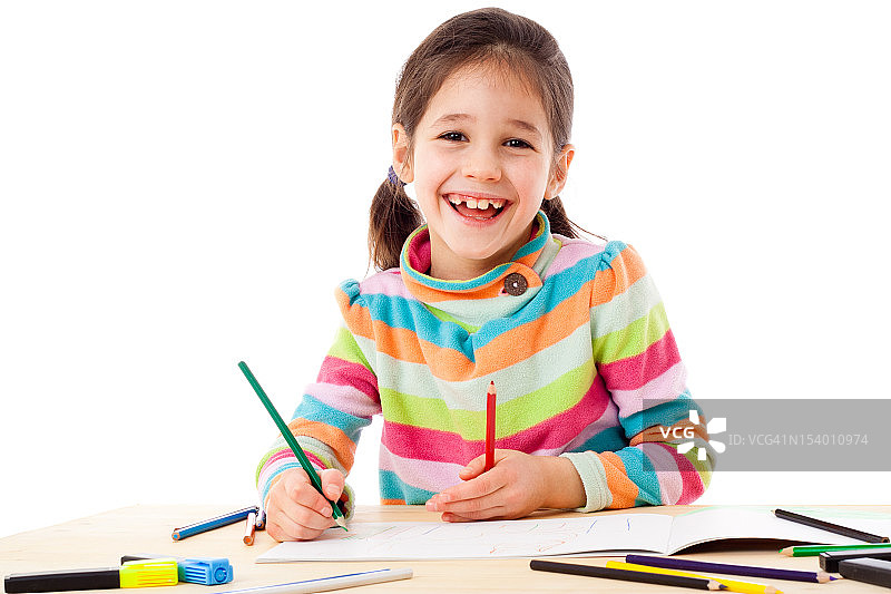 小女孩微笑着用蜡笔画画图片素材