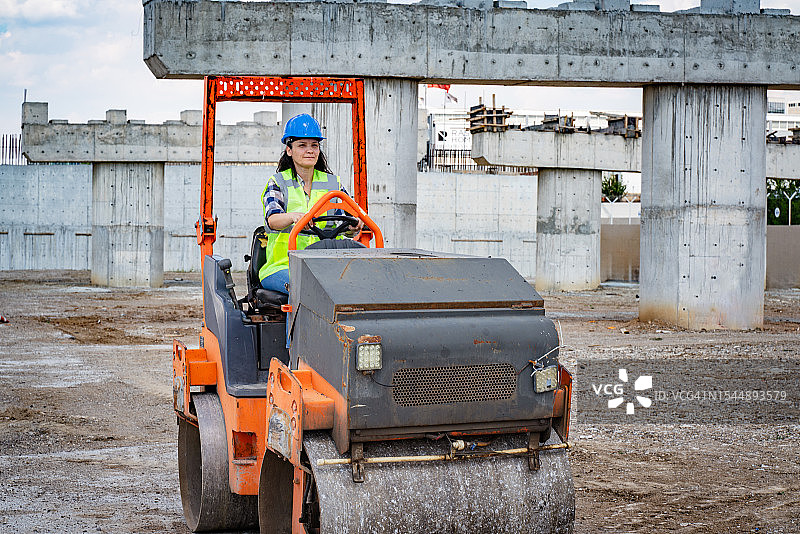 女建筑工人驾驶压路机图片素材