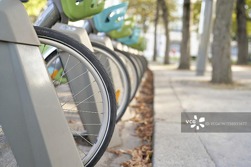 巴黎一个公园的停车场里，一群带着篮子的自行车的侧面和特写。图片素材