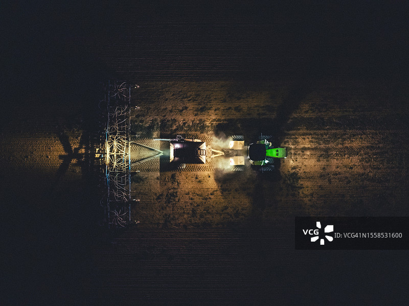 从无人机的角度拍摄的夜间拖拉机耕作，澳大利亚南澳大利亚图片素材