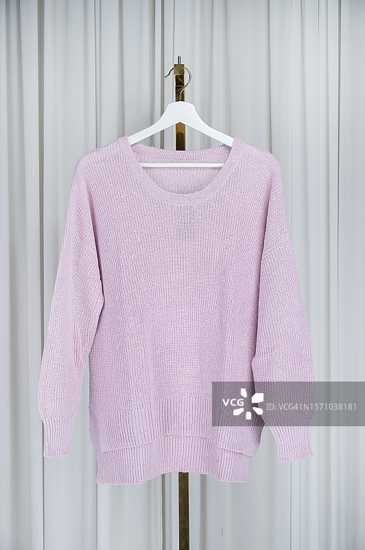 舒适的粉红色毛衣衣架-时尚的冬季服装图片素材
