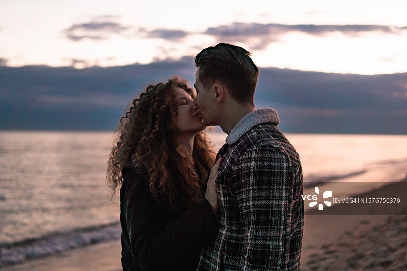 年轻的情侣在海滩上享受爱情图片素材