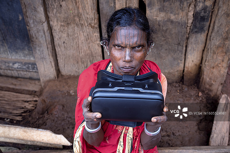 一位来自印度奥里萨邦部落的女士第一次戴着虚拟现实眼镜玩游戏。图片素材