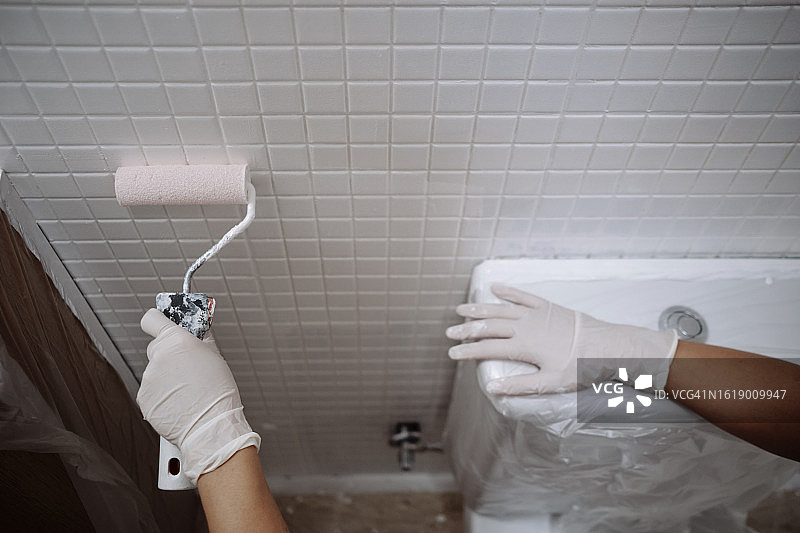 女工人粉刷浴室天花板图片素材