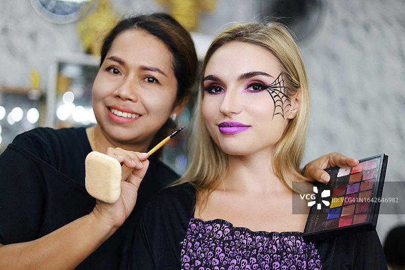 两位女化妆师和她的模特在女巫万圣节庆祝活动的肖像。图片素材