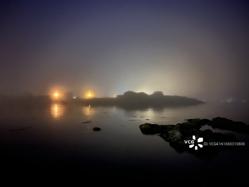 浓雾笼罩着缅因州的海岸，夜晚灯火通明图片素材
