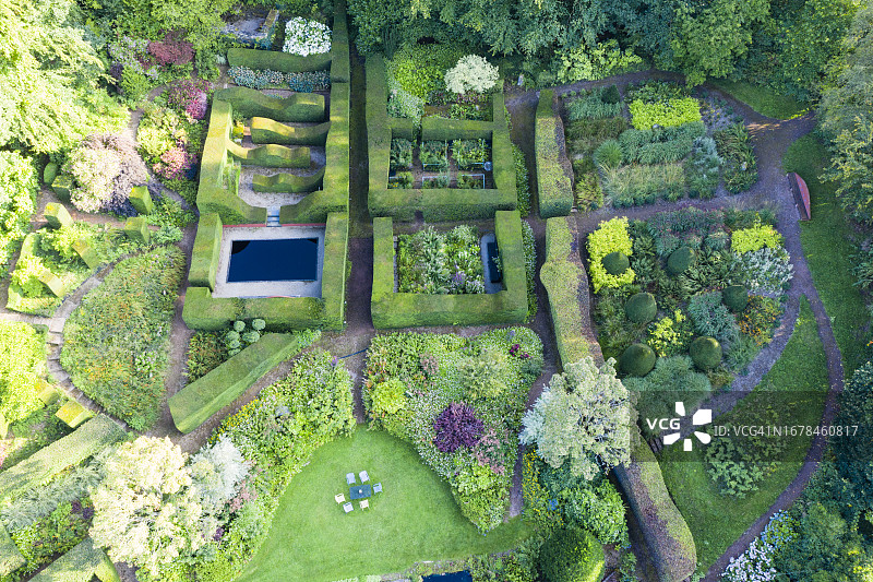 从花园的南侧俯瞰，花园中有几个小花园，其中有修剪过的水杉树篱;英国威尔士蒙茅斯郡Veddw住宅花园。9月。夏天。无人机拍摄的图像。图片素材