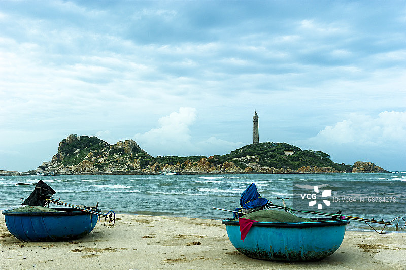 海滩上的小船，背景是灯塔图片素材