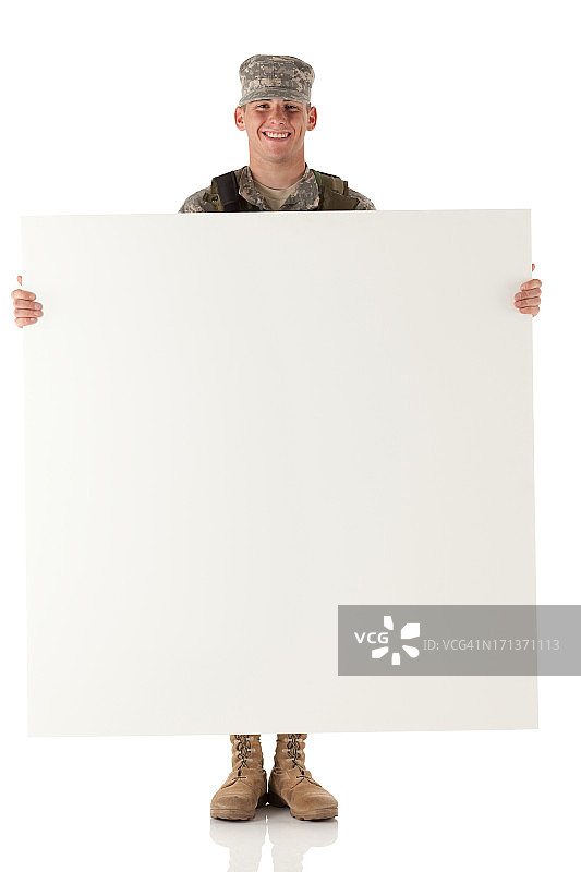 一个军人拿着一块白板，面带微笑图片素材