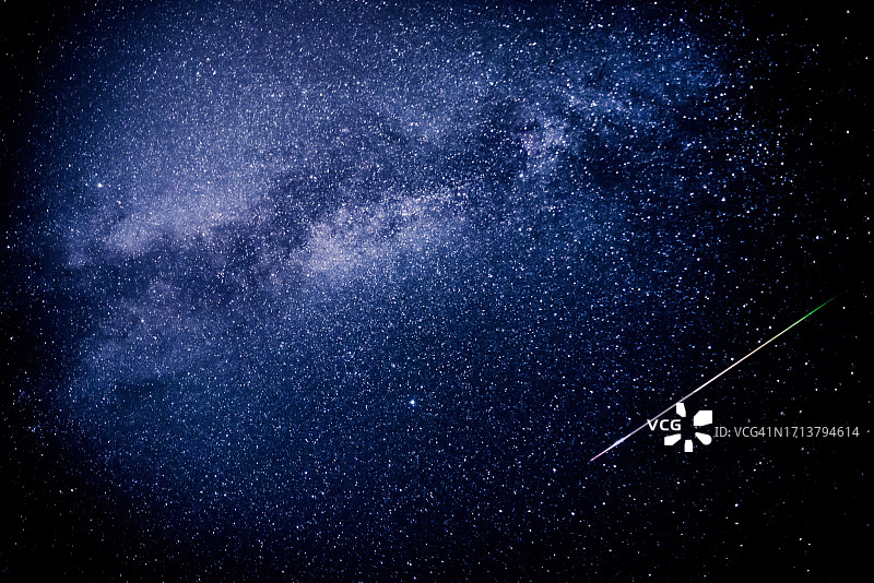 2023年英仙座流星雨期间，一颗流星在天空中留下五彩缤纷的光迹，穿过银河系图片素材