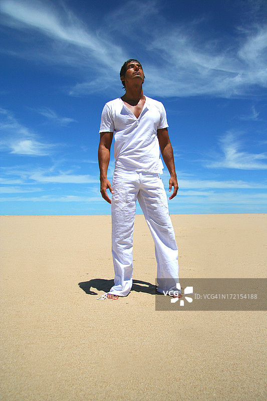 年轻人站在沙滩上放松图片素材