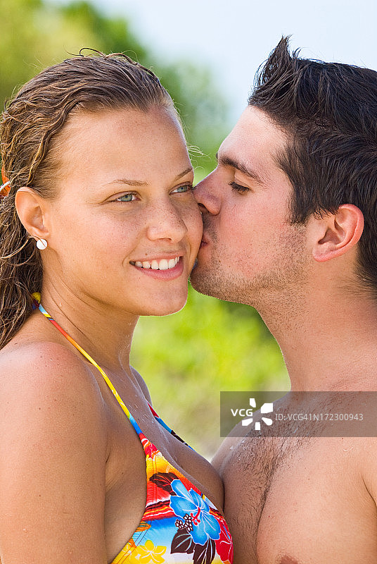 一对幸福的情侣在热带海滩拥抱图片素材