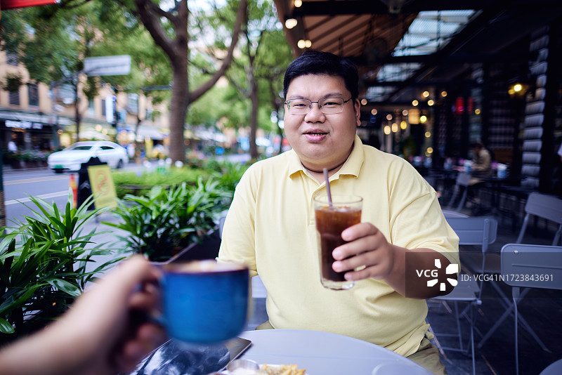 胖胖的中国男人和朋友在户外喝咖啡图片素材