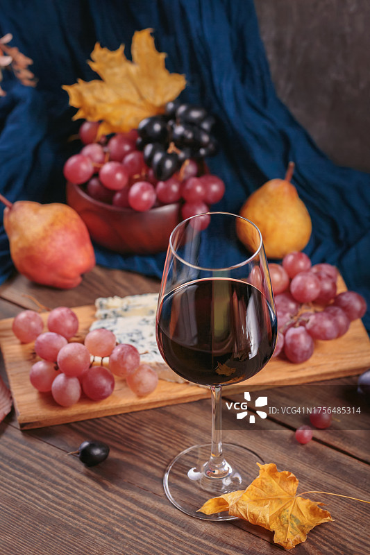 红酒，芝士盘，时令水果和干燥的秋叶图片素材